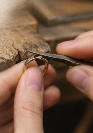 Finishing touches on a ring using fine tweezers